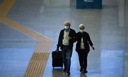 An elderly couple of travelers walk across a terminal at Rome's Fiumicino airport on June 3, 2020, as airports and borders reopen for tourists and residents free to travel across the country, within the COVID-19 infection, caused by the novel coronavirus. (Photo by Filippo MONTEFORTE / AFP)