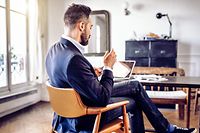 bearded business man reading on mobile in home office