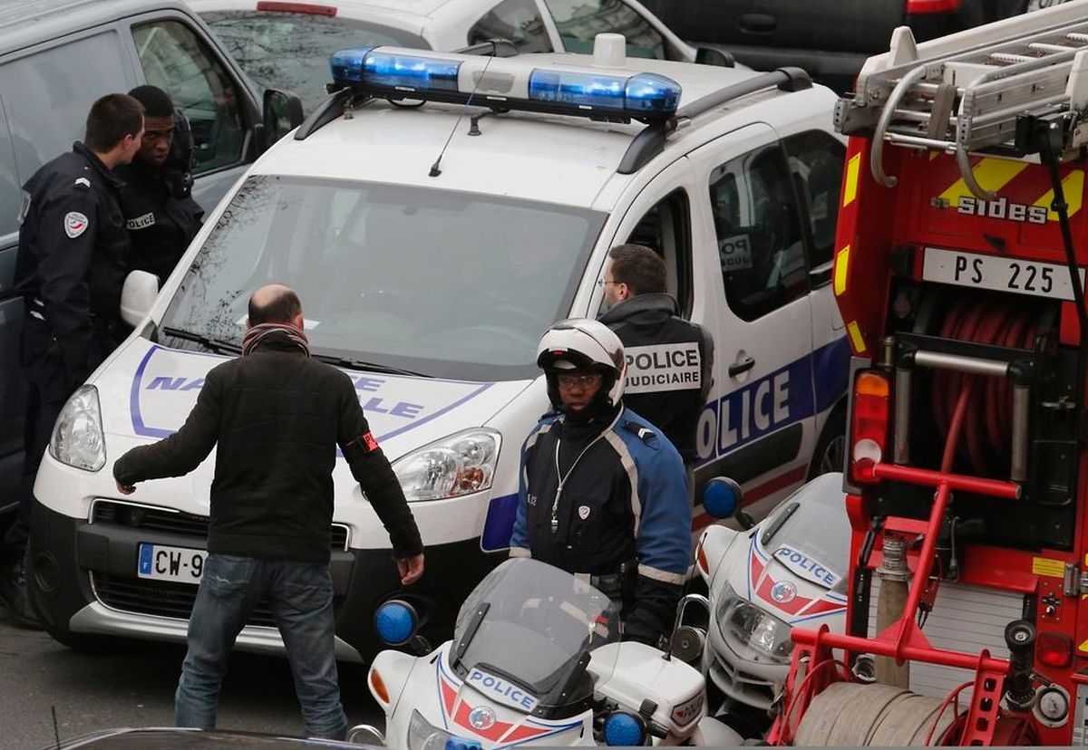 Policemen work at the scene after a shooting at the Paris offices of Charlie Hebdo, a satirical newspaper, January 7, 2015. Eleven people were killed and 10 injured in shooting at the Paris offices of the satirical weekly Charlie Hebdo, already the target of a firebombing in 2011 after publishing cartoons deriding Prophet Mohammad on its cover, police spokesman said. Five of the injured were in a critical condition, said the spokesman. Separately, the government said it was raising France's national security level to the highest notch. REUTERS/Christian Hartmann (FRANCE - Tags: POLITICS CRIME LAW)