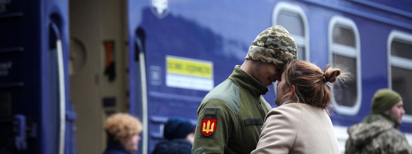 Mulher despede-se de soldado ucraniano, antes de fugir do país. 