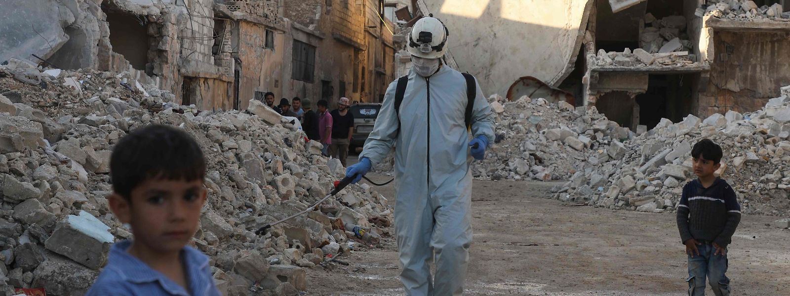Ein Mitglied des Syrischen Zivilschutzes desinfiziert eine zerstörte Nachbarschaft in Atareb.