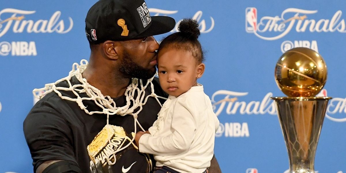LeBron James mit seinem Töchterchen präsentiert den Pokal.