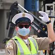 A Los Angeles traffic officer wear a mask as he directs traffic on March 24, 2020. - In California, already under orders to stay home, Governor Gavin Newsom tightened the lockdown to shut parking lots at beaches and parks after tens of thousands flouted social distancing rules. (Photo by Frederic J. BROWN / AFP)