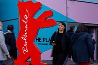 People walk past the logo of the upcoming Berlinale 73rd International Film Festival in Berlin on February 15, 2023. - The Berlin film festival, Europe's first major cinema showcase of the year, opens on February 16, 2023 with a focus on the fight for freedom in Ukraine and Iran and the starriest line-up in years. The 73rd Berlinale, traditionally the most politically minded of the big three European festivals, will coincide with the first anniversary of the start of the Russian onslaught in the Ukraine. (Photo by David GANNON / AFP)