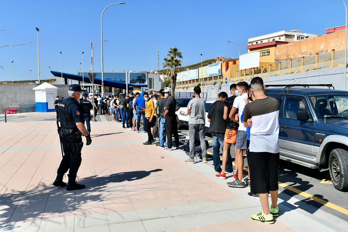 Migranten aus Marokko stehen an den Toren der Grenze zu Ceuta Schlange, wo Beamte der spanischen Polizei Termine für Asylanträge ausgeben. 