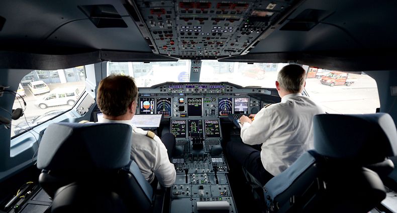 Picture taken on June 4, 2014 in Hamburg, northern Germany shows pilots in a cockpit of an airbus A380 operated by German airline Lufthansa. The Austrian aviation authority Austro Control imposed on March 27, 2015 the presence of two crew members in the cockpit throughout the flight, following the crash of the Germanwings Airbus on March 24, 2015, announced the Ministry of Transportation. AFP PHOTO / DPA / DANIEL REINHARDT GERMANY OUT