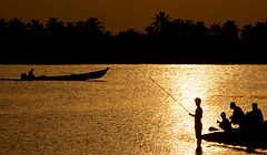 TOPSHOT - Iraqis fish at the Shatt al-Arab river, formed by the confluence of the Euphrates and the Tigris, near Basra in southern Iraq, on April 28, 2020 during the Muslim holy month of Ramadan. (Photo by Hussein FALEH / AFP)