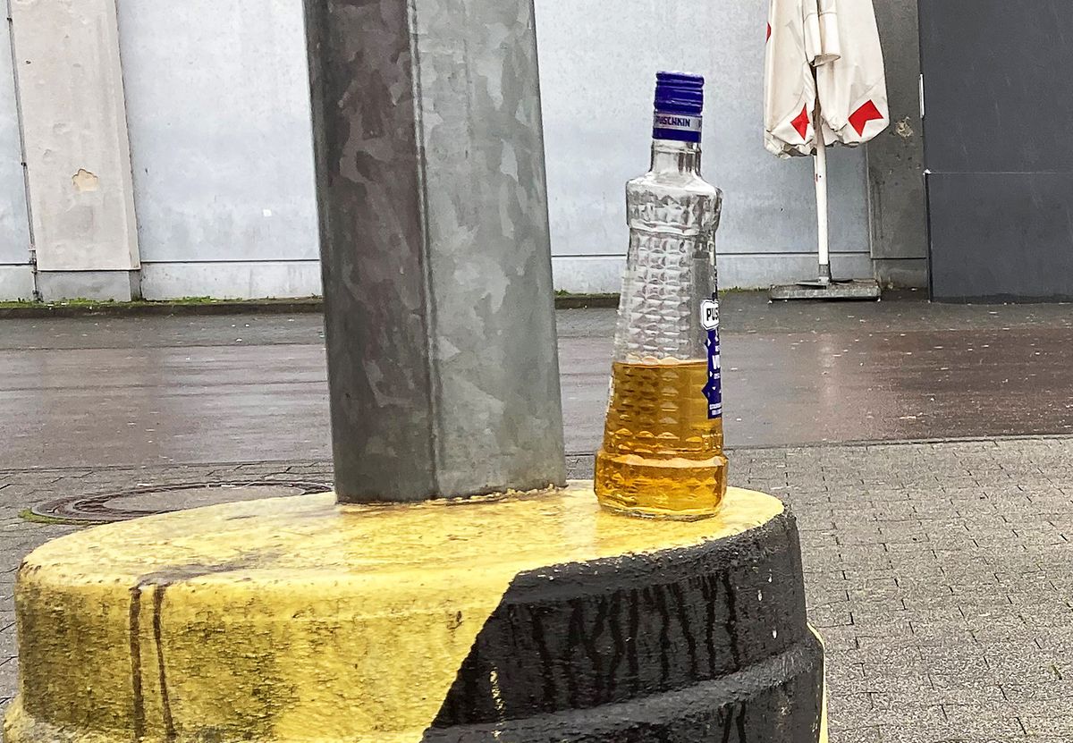 Eine Vodka-Flasche steht am Morgen nach dem Polizeieinsatz auf dem Parkplatz vor dem Club, an dessen Türen die Situation eskaliert ist.