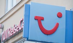 An einem Reisebüro hängt das Firmen-Schild mit dem Logo des Reiseveranstalters Tui.