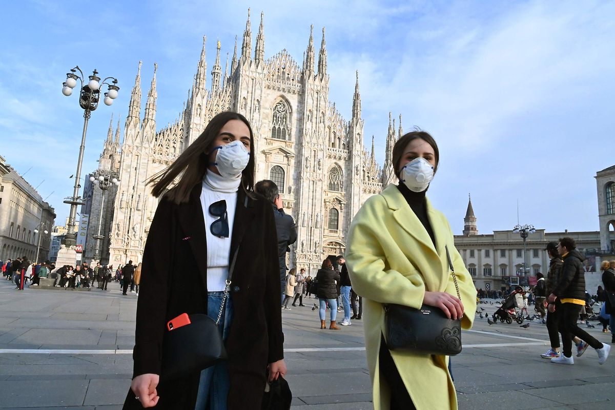 Passanten mit Grippeschutzmasken auf der Piazza del Duomo in Mailand. 