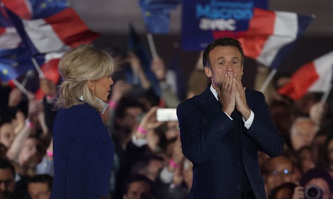French President Emmanuel Macron and his wife Brigitte Macron celebrate after his victory in France's presidential election, at the Champ de Mars in Paris, on Sunday