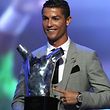 Real Madrid's Portuguese forward Cristiano Ronaldo gestures as he poses with the trophy after he was awarded the title of "Best Men's Player in Europe" at the conclusion of the UEFA Champions League group stage draw ceremony in Monaco on August 24, 2017.  / AFP PHOTO / VALERY HACHE
