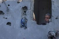 Um homem palestiniano inspeciona os danos na sua casa após um bombardeamento israelita em Rafah, no sul da Faixa de Gaza, em 18 de outubro de 2023, no meio de batalhas contínuas entre Israel e o Hamas.  