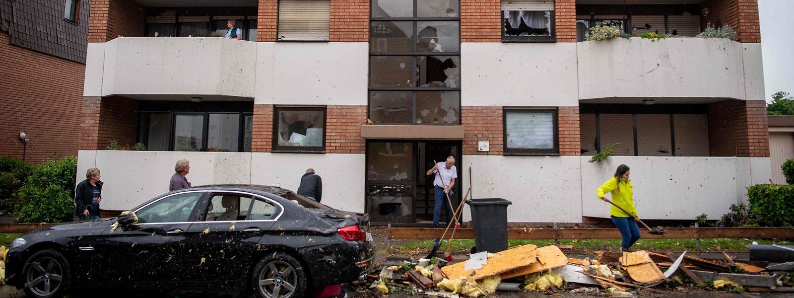 Des habitants dégagent les débris devant un immeuble d'habitation à Paderborn, dans l'ouest de l'Allemagne.