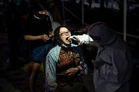 TOPSHOT - This photo taken on August 3, 2021 shows a resident receiving a nucleic acid test for the coronavirus in Wuhan in China's central Hubei province. (Photo by STR / AFP) / China OUT
