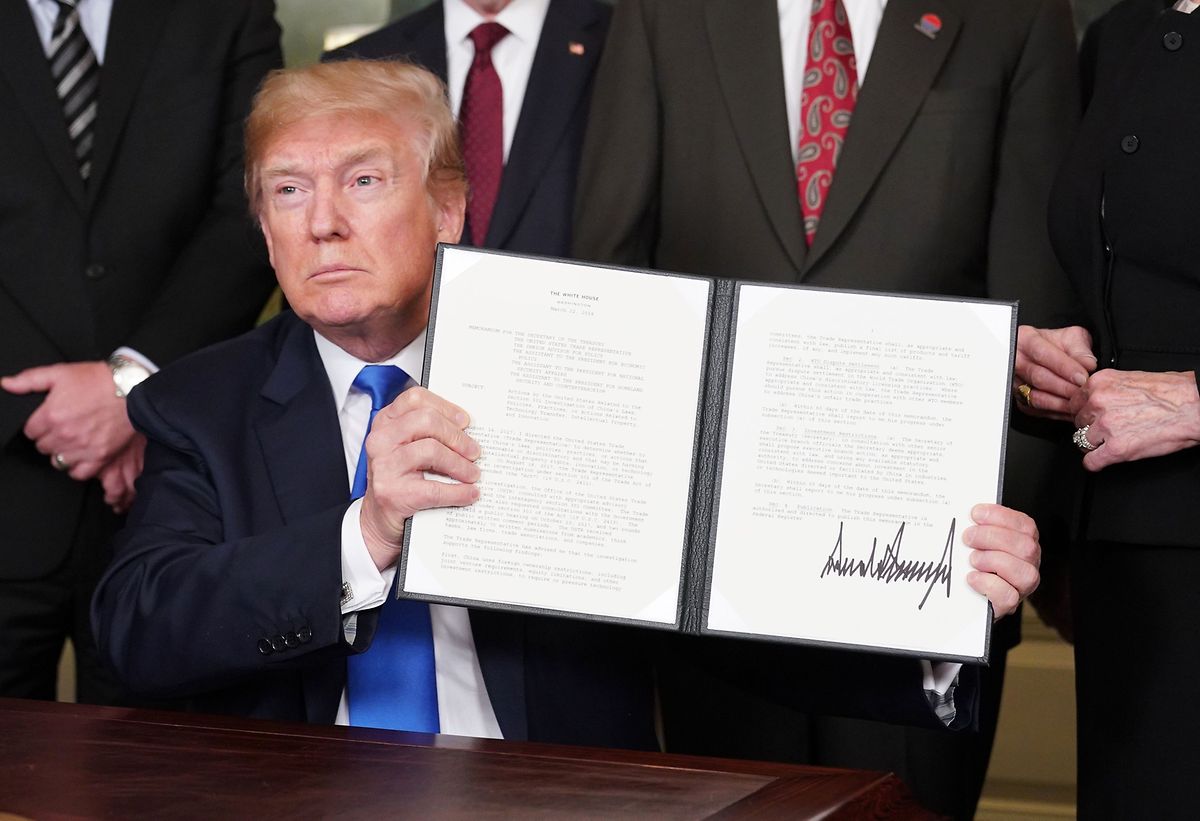 US President Donald Trump signs trade sanctions against China on 22 March (AFP)