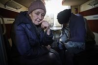 Anna (L), 76, and her husband Anatoliy, 86, sit on a train during an evacuation in Pokrovsk, Donetsk region, November 30, 2022, amid the Russian invasion of the Ukraine.  (Photo by ANATOLII STEPANOV / AFP)