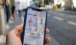 (FILES) In this file photo taken on May 27, 2020, a man holds a mobile phone diplaying a screenshot of the tracking application StopCovid developed by the French government in an attempt to contain the spread of COVID-19, in Paris, as France eases lockdown measures taken to fight against the novel coronavirus. - France's StopCovid mobile app, a voluntary system designed to alert users if they have been in close proximity of someone who has tested positive for the virus, was made available on June 2, 2020. (Photo by Thomas SAMSON / AFP)