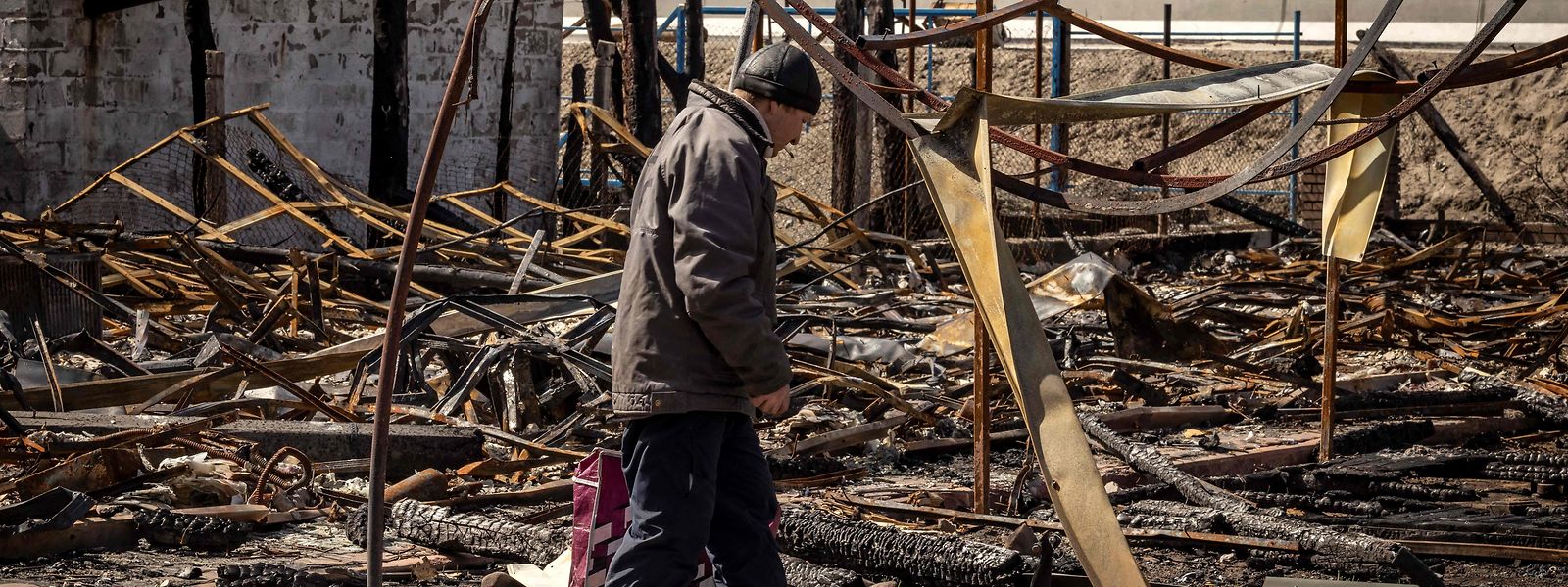 Ein Mann geht durch die Trümmern seines Hauses, das nach einem russischen Luftangriff komplett zerstört ist.