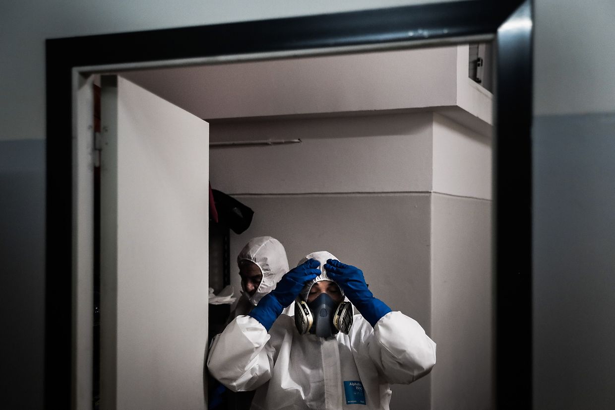 A vestir os fatos de proteção antes de fecharem um caixão. 