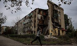 TOPSHOT - A man runs in front of a destroyed apartment building in Bakhmut, Donetsk region on September 26, 2022, amid Russia's invasion of Ukraine. (Photo by ANATOLII STEPANOV / AFP)