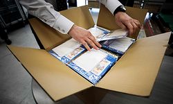 A Japan Post employee opens a box of face masks, known as "Abenomasks" (Abe's masks), which will be distributed among residents to help against the spread of the COVID-19 coronavirus, after their delivery to a post office in Tokyo on April 16, 2020. - A pledge earlier this month by Japan's Prime Minister Shinzo Abe to send two reusable cloth face masks to every household as the country battles the coronavirus outbreak was met online with derision and humour. (Photo by Behrouz MEHRI / AFP)