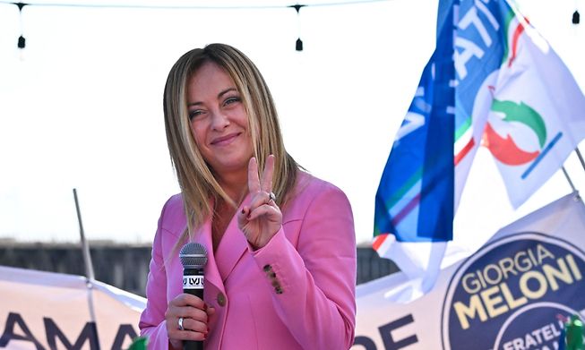 Giorgia Meloni, the leader of Italian far-right party Fratelli d'Italia (Brothers of Italy), flashes the victory sign as she delivers a speech on Friday in Naples during a rally closing her party's election campaign.
