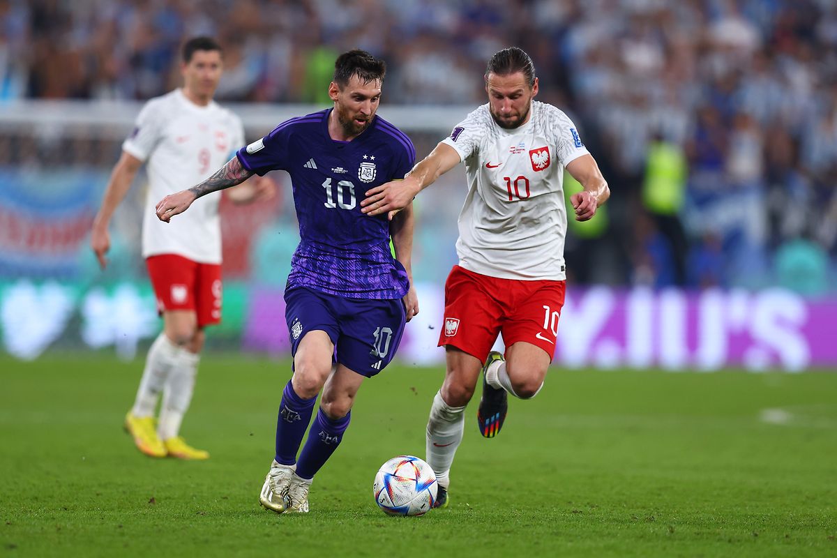 Polens Grzegorz Krychowiak (r) und Argentiniens Lionel Messi kämpfen untern den Augen von Polens Robert Lewandowski (l) um den Ball. 