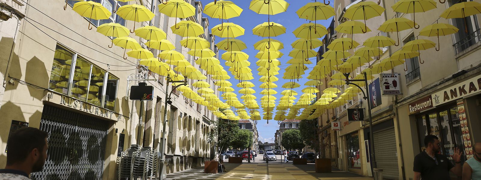 Une nuée de parapluies jaunes a été suspendue au-dessus de la rue piétonne Aristide-Briand.