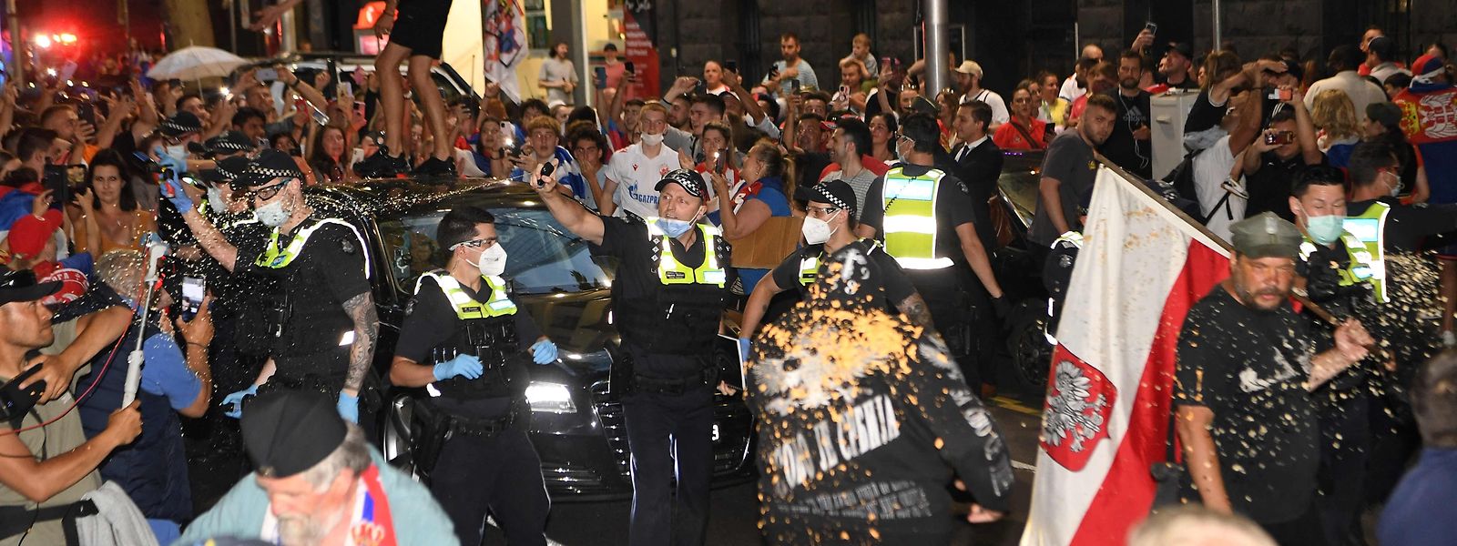 Polizisten setzen Pfefferspray gegen randalierende Novak-Djokovic-Fans ein.