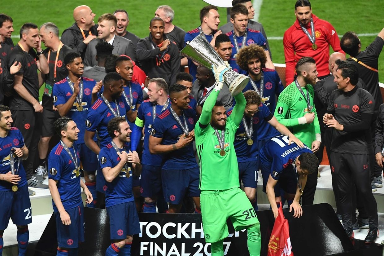 Manchester United's Argentinian goalkeeper Sergio Romero celebrates with the trophy and the team after the UEFA Europa League final football match Ajax Amsterdam v Manchester United on May 24, 2017 at the Friends Arena in Solna outside Stockholm. / AFP PHOTO / JANEK SKARZYNSKI