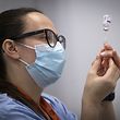 A member of the vaccine team prepares a syringe with a dose of the AstraZeneca/Oxford Covid-19 vaccine, at an NHS Scotland vaccination centre set up at the Edinburgh International Conference Centre (EICC) in Edinburgh on February 1, 2021. - Britain is under a third national lockdown as it battles a new strain of the virus and has recorded more than 106,000 deaths from the disease -- the worst toll in Europe. (Photo by Jane Barlow / POOL / AFP)