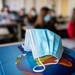 ARCHIVE - November 17, 2020, Bavaria, Munich: ILLUSTRATION - A mouth and nose mask is in class at a geography seminar in grade 11 at the state Trudering High School on Weltalas, in the background students with mouth and nose protection are seen.  Before another round of heads of government, which may also include new crowning rules in schools, experts recommend that mouth and nose protectors are properly worn.  (to dpa «Experts: well-fitting masks and ventilation are important in school lessons») Photo: Matthias Balk / dpa +++ dpa-Bildfunk +++