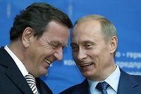 (FILES) This file photo taken on July 8, 2004 shows then Russian President Vladimir Putin (R) and then German Chancellor Gerhard Schroeder sharing a smile while they take part in the Russian-German economic forum in Moscow. - Former German chancellor Gerhard Schroeder's close friendship with President Vladimir Putin and lucrative business dealings with Russia have for years been reluctantly tolerated at home. But as war clouds gather over Ukraine and allies question Germany's resolve, Schroeder is increasingly seen as potential liability to new chancellor and fellow Social Democrat Olaf Scholz, fuelling calls for a clean break with the pro-Kremlin lobbyist. (Photo by MAXIM MARMUR / AFP)