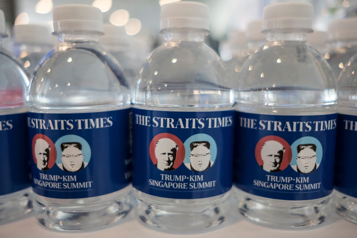 Die Konterfeis von US-Präsident Trump und dem nordkoreanischen Machthaber Kim sind auf Wasserflaschenetiketten abgebildet, die im Pressezentrum für Journalisten bereit stehen. 