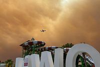 28.07.2021, Türkei, Side: Rauch zieht über die Freizeitanlagen an einem Hotelkomplex in der türkischen Urlaubsregion Antalya, während sich ein Flugzeug im Landeanflug befindet. Winde trieben die Flammen mehrerer Waldbrände in Richtung der Wohnbezirke, wie der Landrat des Bezirks Manavgat dem Sender CNN Türk sagte. (Bestmögliche Qualität) Foto: Cevin Dettlaff/dpa-Zentralbild/dpa +++ dpa-Bildfunk +++