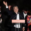 Hungarian Prime Minister Viktor Orban (C) and members of his FIDESZ party celebrate from the podium on the bank of the Danube River after winning the parliamentary election on April 8, 2018 in Budapest. The words on the lectern read 'Hungary is first for us!' / AFP PHOTO / ATTILA KISBENEDEK