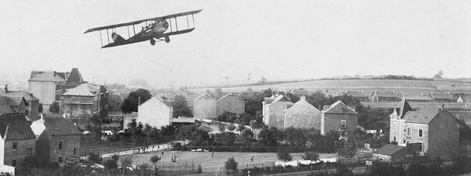 Anschauungsbild: Auf der zeitgenössischen Fotomontage fliegt ein Flugzeug über Düdelingen. 