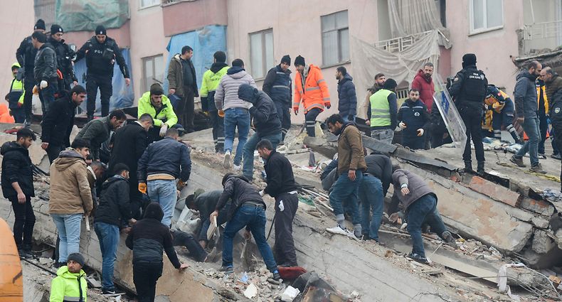 People search for survivors through the rubble in Diyarbakir, on February 6, 2023, after a 7.8-magnitude earthquake struck the country's south-east. - At least 284 people died in Turkey and more than 2,300 people were injured in one of Turkey's biggest quakes in at least a century, as search and rescue work continue in several major cities. (Photo by ILYAS AKENGIN / AFP)