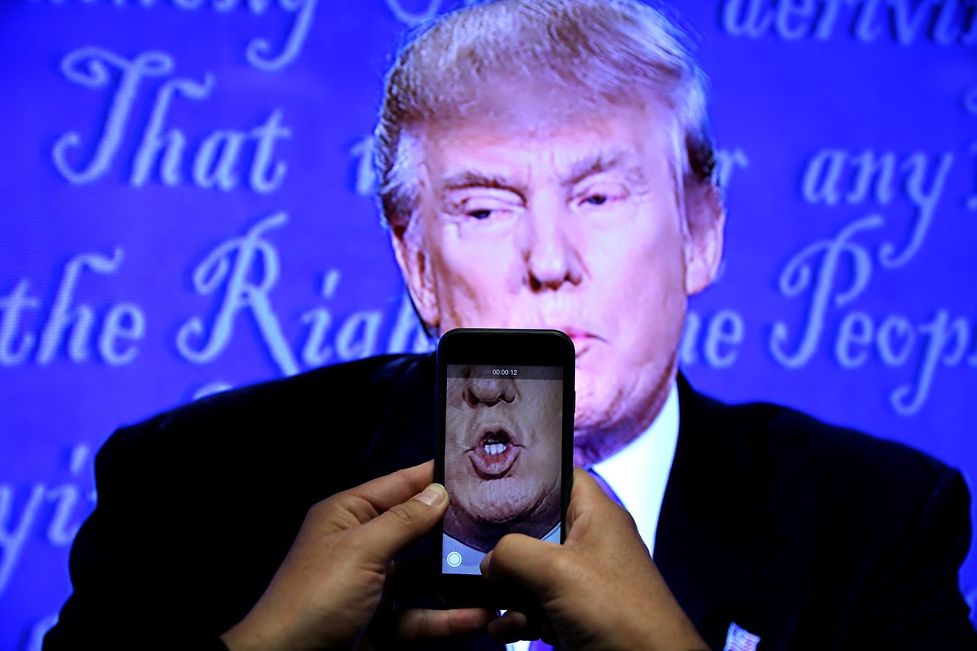 A journalist records a video from screen as Republican U.S. presidential nominee Donald Trump speaks during the first presidential debate