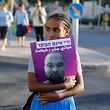 TOPSHOT - An Israeli woman holds a poster of Solomon Tekah, a young man of Ethiopian origin who was killed by an off-duty police officer, as members of the Israeli Ethiopian community block the main entrance to Jerusalem on July 2, 2019 to protest his killing. - Protests in Israel over an off-duty police officer's killing of a young man of Ethiopian origin renewed today, as the incident drew fresh accusations of racism. Crowds of Ethiopian-Israelis battled police and blocked highways in at least 10 junctions across the country beginning in the late afternoon, with over a dozen protesters detained and thousands of motorists held motionless in huge traffic jams. Teka was shot in Kiryat Haim, a town near the northern port city of Haifa, late on June 30. (Photo by MENAHEM KAHANA / AFP)