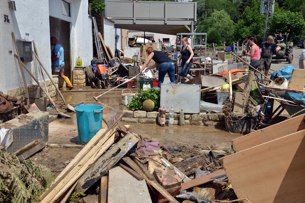 Helfer beseitigen ein Wohnhaus in Dudeldorf (D) von den Schlammmassen. Teile des Orts sind am Samstag Abend von einem Unwetter teilweise überschwemmt worden. 