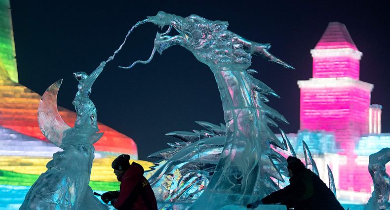 Ice sculptors give finishing touches on an ice sculpture at the Harbin Ice and Snow World festival in Harbin, in China's northeast Heilongjiang province on January 3, 2020. (Photo by NOEL CELIS / AFP)