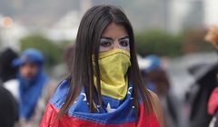 23.01.2019, Venezuela, Caracas: Eine Frau hat sich mit einer venezolanischen Flagge maskiert und protestiert gegen den venezolanischen Präsidenten Maduro. Der venezolanische Parlamentspräsident Guaidó hat die sozialistische Regierung von Maduro für entmachtet erklärt und sich selber zum Übergangs-Staatschef ausgerufen. Minuten später erkannte US-Präsident Donald Trump den Oppositionsführer als rechtmäßigen Übergangspräsidenten des von Korruption und Armut geplagten Landes an. Maduro verfügte daraufhin am Mittwoch den Abbruch der diplomatischen Beziehungen zu den USA. Das mächtige Militär stellte sich in dem erbitterten Machtkampf hinter Maduro. Foto: Boris Vergara/dpa +++ dpa-Bildfunk +++