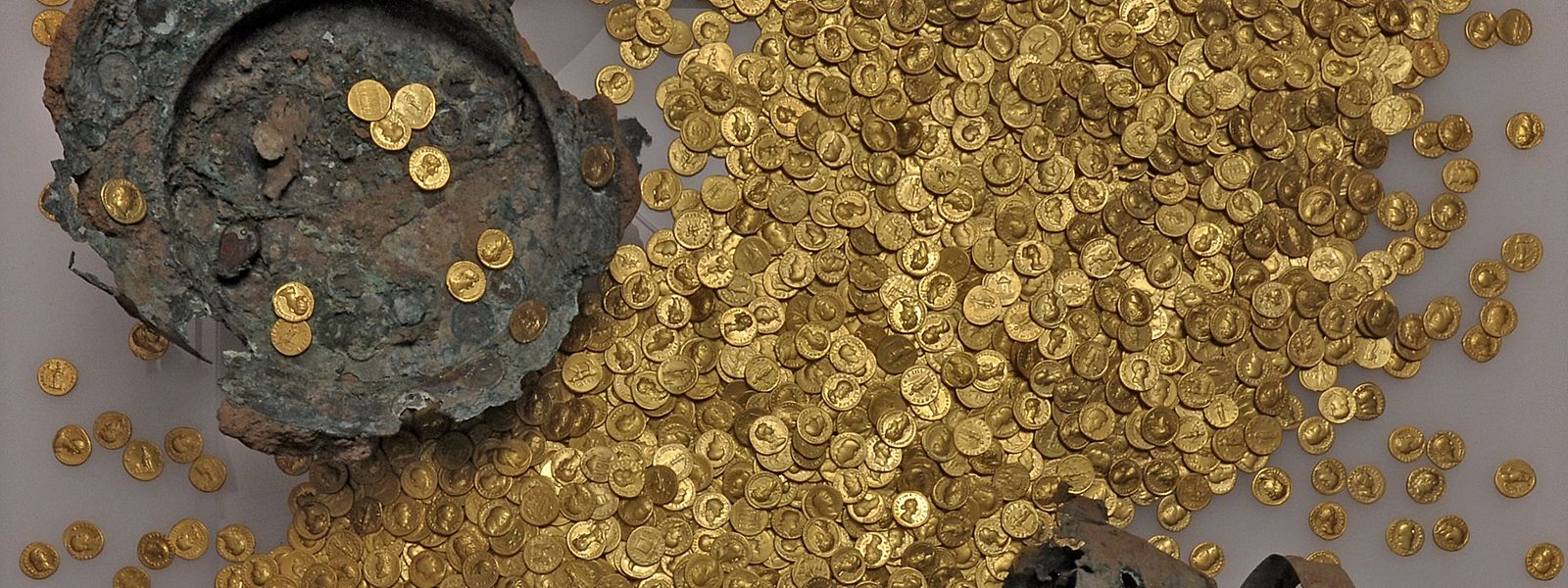 Ein Teil der Münzen mit dem beschädigten Kupfergefäß. 