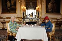 TOPSHOT - An undated handout photograph released by Buckingham Palace on June 4, 2022, shows Queen Elizabeth II and Paddington Bear having cream tea at Buckingham Palace, taken from a film that was shown at the BBC Platinum Party at the Palace on June 4, 2022. - Some 22,000 people and millions more at home are expected at a star-studded musical celebration for Queen Elizabeth II's historic Platinum Jubilee. (Photo by BUCKINGHAM PALACE / AFP) / XGTY / RESTRICTED TO EDITORIAL USE - MANDATORY CREDIT "AFP PHOTO /  BUCKINGHAM PALACE/ STUDIO CANAL / BBC STUDIOS / HEYDAY FILMS" - NO MARKETING - NO ADVERTISING CAMPAIGNS - NO DIGITAL ALTERATION ALLOWED  - DISTRIBUTED AS A SERVICE TO CLIENTS - NO ARCHIVES - NOT TO BE USED AFTER JUNE 30, 2022 / 