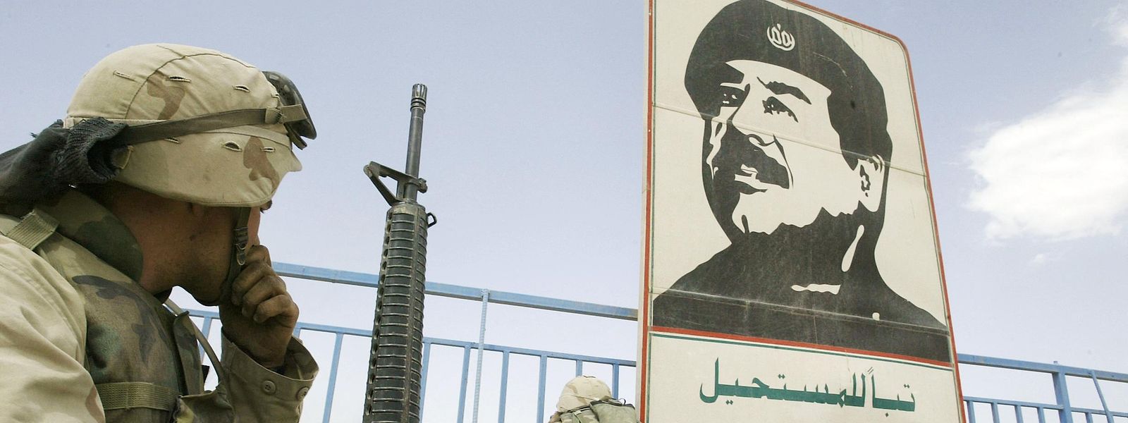 US-Marines am 10. April 2003 neben einem Porträt Saddam Husseins in einem Stadion in Bagdad.