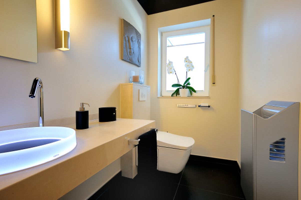 Berührungslos: Dieses moderne Bad mit Dusch-WC verfügt über ein Waschbecken mit Sensortechnik und einen automatischen Händetrockner.