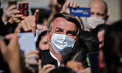 TOPSHOT - Brazilian President Jair Bolsonaro gestures as he is surrounded by supporters while visiting the residence of an adviser in Bras�lia, on August 23, 2020. - Bolsonaro on Sunday threatened to punch a reporter repeatedly in the mouth after being asked about his wife's links to an alleged corruption scheme. "I so want to pound your mouth with punches," the far-right president said when a reporter from O Globo, posed the question. (Photo by Sergio Lima / AFP)