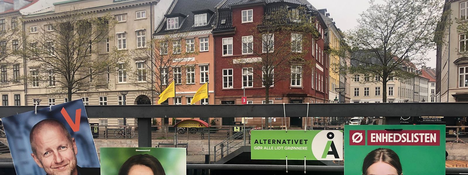 Wahlplakate verschiedener Parteien hängen an einem Geländer neben einem Kanal in Kopenhagen. 